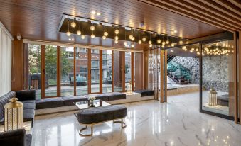 The modern home features a lobby adorned with large windows and a chandelier at Orion Hotel & Residence