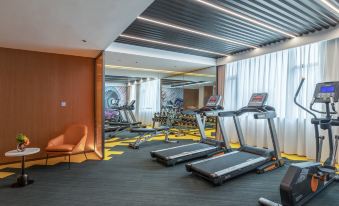 The room is spacious and contains multiple exercise equipment, including an indoor gym area at Hilton Hampton Hotel, West Coast, Qingdao