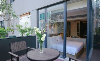 A bedroom with large windows and a balcony overlooks the outside, featuring an unmade bed at Paco  Hotel (Jiangmen Xinhui Times)