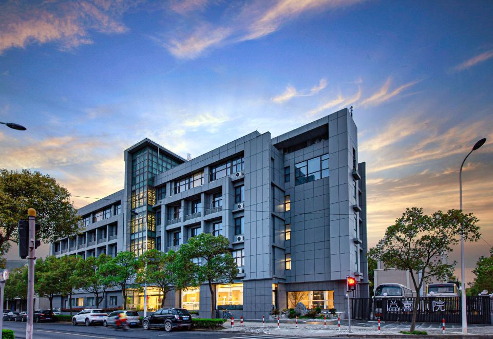 A large building consists of an office block in the middle and a hotel on the upper side at Shanghai JOYFUL YARD Hotel (Shanghai Pudong Airport Store)