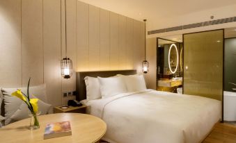 bedroom with a large bed and a table in the center, accompanied by an enclosed space at LN Garden Hotel Guangzhou