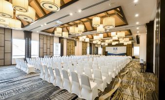 a large , empty conference room with rows of white chairs and a podium in the center at Tui Blue Nam Hoi An