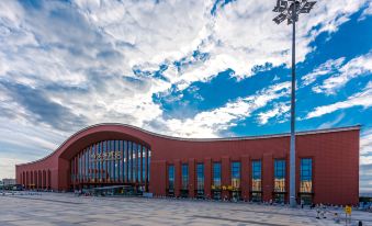 A large building with a view of the blue sky in front at Metropolo Jinjiang Hotel (Harbin Haxi High-speed Railway Station Wanda Plaza)