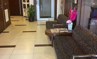 a hotel lobby with a couch , chairs , and a coffee table in the center of the room at Jewels Hotel
