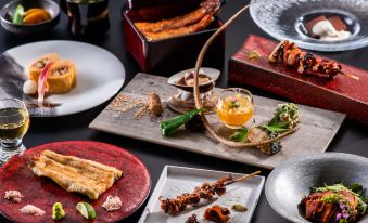 a table is filled with various dishes and sauces , including a red tray with food at Art Hotel Miyazaki Sky Tower