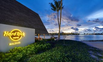 "a beach resort with a sign that reads "" ocean rock inn "" and a palm tree in the background" at Hard Rock Hotel Maldives - Complimentary Roundtrip Speed Boat Transfer Until 31st October 2025