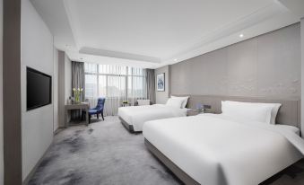 In a modern bedroom, there are large windows, double beds, and a table in the middle at Byland Star Hotel (Yiwu International Trade City)