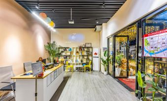 The restaurant's interior design features tables and chairs, with plants placed on both sides in the front at Yue City Youth Apartment