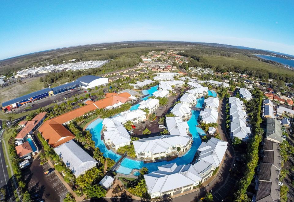 a bird 's eye view of a resort with a large pool surrounded by multiple buildings at Oaks Port Stephens Pacific Blue Resort