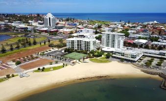 a bird 's eye view of a beach with tall buildings and the ocean in the background at Bunbury Hotel Koombana Bay