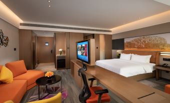 A spacious room is furnished with a bed, desk, and chair in the center, resembling an oriental style at Hampton by Hilton Beijing Guomao CBD