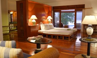 a spacious bedroom with hardwood floors , a king - sized bed , and a view of the ocean at Badian Island Wellness Resort