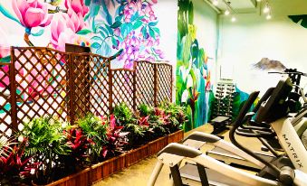 There is a gym with murals on the walls and flowers in front, as well as an exercise room at Burlington Hotel