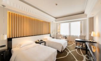 The bedroom features two double beds and a large window with a view of the bay at Inspirock Hotel