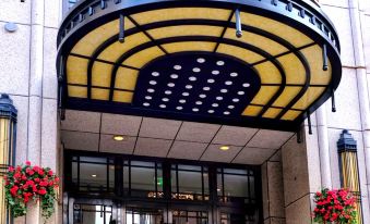 The front entrance of a hotel features large arched doors and an ornate sign above it at Shanghai Jinjiang Metropolo Classic East Nanjing Road Hotel