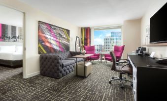 a living room with a couch , chairs , and a tv . also a dining table in the room at Hyatt Centric Arlington