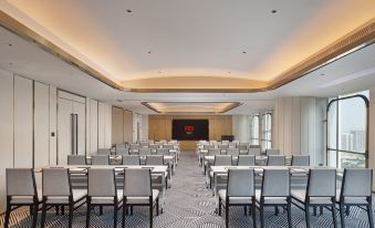 A spacious room with tables and chairs arranged in the center, suitable for hosting events or conferences at Radisson RED Guang Zhou South Railway Station