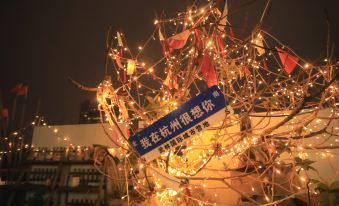 There is a large number of lights and signs on a tree in front of a hotel at night at Hangzhou Wulin International City Camp (West Lake Wulin Gate Subway Station Store)