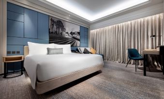 A spacious bedroom with a large bed and a chair in the center, accompanied by an open area at Lisboeta Macau