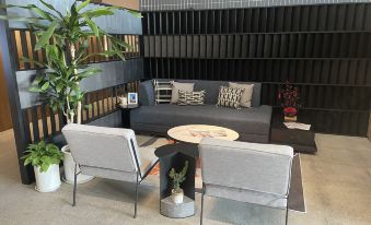 Another setup in the room includes a living room with two chairs and an L-shaped couch at base SUHE Serviced Apartment
