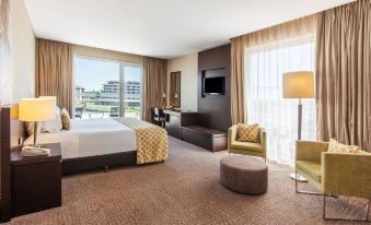 a spacious hotel room with a king - sized bed , a flat - screen tv , and a view of the city at Wyndham Nordelta Tigre Buenos Aires