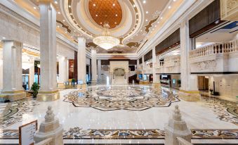 The large building features a lobby and main room adorned with marble floors and chandeliers at Inspirock Hotel