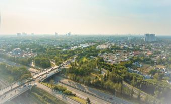 an aerial view of a city with a bridge and traffic on the road , surrounded by trees and buildings at Swiss-Belhotel Serpong