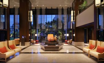 a modern hotel lobby with a large buddha statue in the center , surrounded by potted plants and potted trees at Hyatt Regency Naha, Okinawa