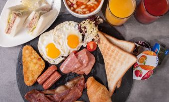 A variety of meats and breakfast items were placed on a plate on the table at B P International