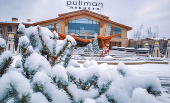 "a large building with a sign that reads "" pullman resort "" is surrounded by snow and pine trees" at Pullman Changbaishan Resort