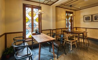 The interior of the establishment features wooden tables and chairs, as well as a glass paneled window at Yiman Hotel (Suzhou Pingjiang Road Scenic Area)