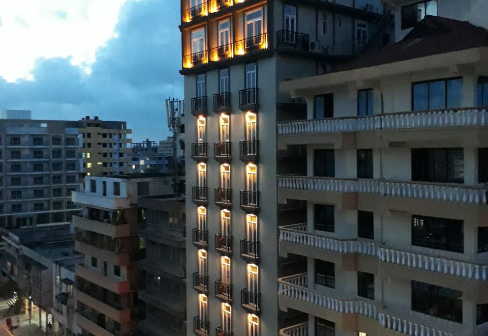 a tall building with many windows and lights on it , located in a city at night at Chelsea Hotel