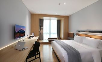 a modern bedroom with large windows, a bed, and a desk in the center area adjacent to the windows at Insio Hotel (Shenzhen Shekou Maritime World)