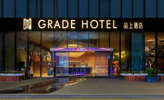 The entrance to a hotel is illuminated at night with a sign above it, and there is another building nearby at Grade Hotel Shenzhen sea world