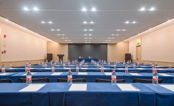 A spacious event room is arranged with blue chairs and tables positioned in the front at Lavande Hotel (Kunming Xishan Wanda Plaza Railway Station)