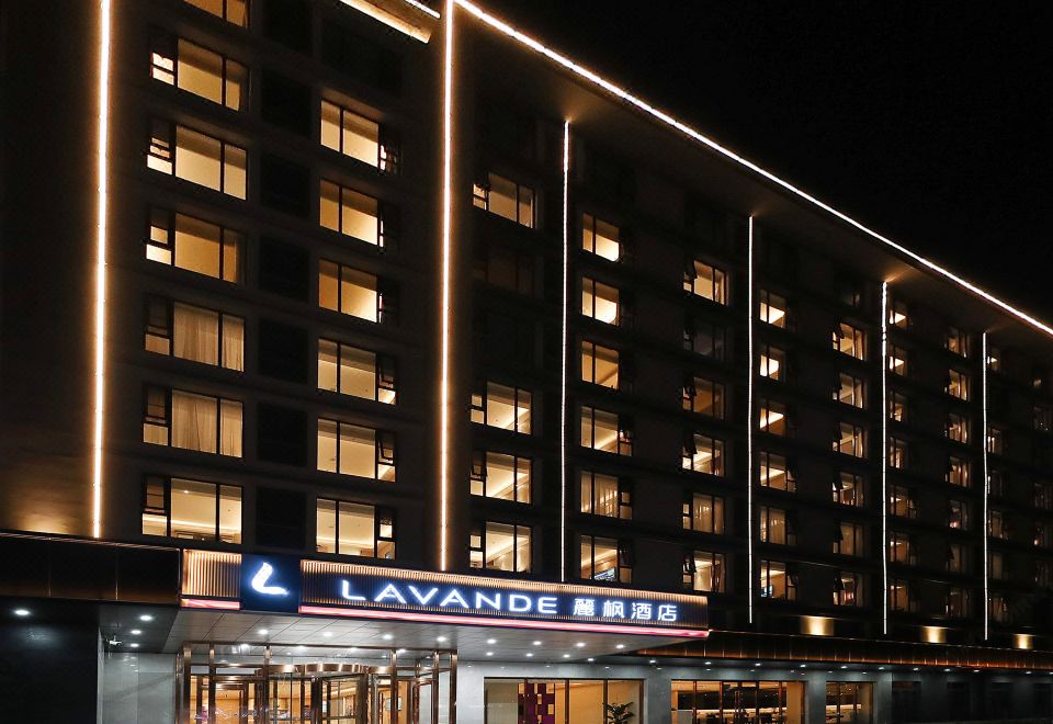 The front view of the hotel and restaurant at night is enhanced by a large sign on top at Lavande Hotel (Beijing Changyang Metro Station)