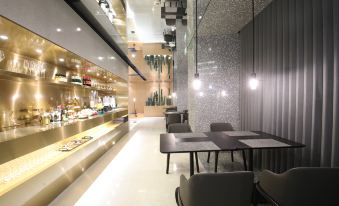 The restaurant is illuminated by overhead lighting and has tables and chairs along the wall at Insio Hotel (Shenzhen Shekou Maritime World)