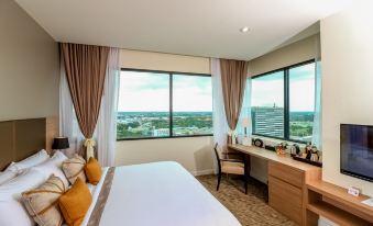 a modern hotel room with a large window offering a view of the city , a comfortable bed , and a desk area at Grand Fortune Hotel Nakhon Si Thammarat