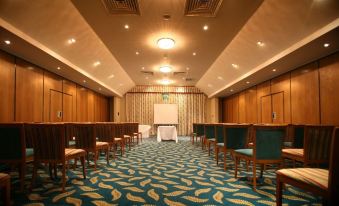 a conference room set up for a meeting , with chairs arranged in rows and a projector on the wall at Dale Hill Hotel