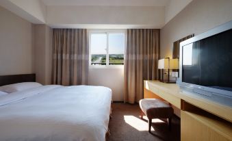 The room is furnished like an executive suite, featuring large windows, a bed, and a desk in the center at City Suites (Taoyuan Gateway)