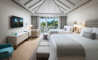 a modern hotel room with two beds , a balcony , and a dining table , all decorated in white and beige colors at The St. Regis Bahia Beach Resort, Puerto Rico