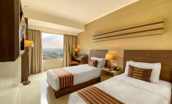 a hotel room with two beds , one on the left and one on the right side of the room at Sapphire Sky Hotel & Conference