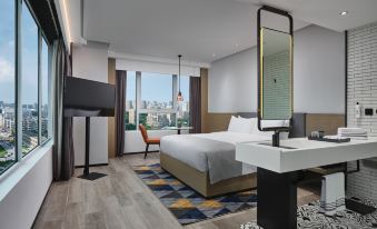 A modern bedroom with large windows, a bed, and a desk in the middle is spacious and bright at Wanda Moments