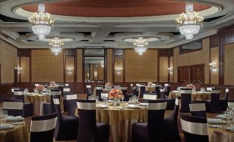 a large dining room with round tables covered in gold tablecloths and chairs arranged around them at The Langham Melbourne