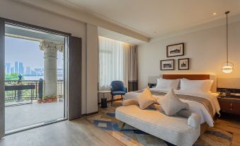 There is a large bed and table in the living room, which has sliding glass doors that lead to an outdoor area at Grand Madison Wuhan Hankou on the Bund