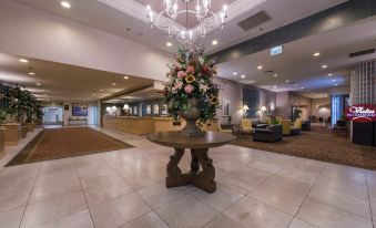 a large hotel lobby with a round table in the center and a chandelier hanging from the ceiling at Grand Vista Hotel