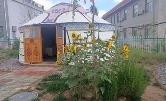 There is a large wooden structure with flowers in the middle, located near an outdoor gazebo and other features at Colorful Danxia Yimi Sunshine Inn