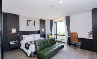 a modern hotel room with a large bed , a couch , and a window overlooking the city at SureStay Hotel by Best Western Vientiane