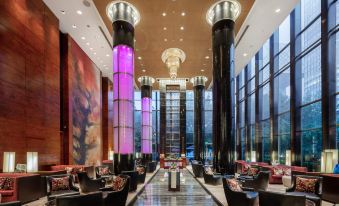 The lobby and dining room of this modern hotel have a large window that overlooks other rooms at Grand Millennium Beijing