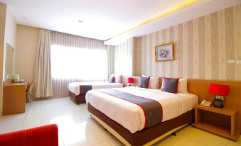 a hotel room with two beds , one on the left side and the other on the right side of the room at Super OYO Collection O Sweet Karina Bandung